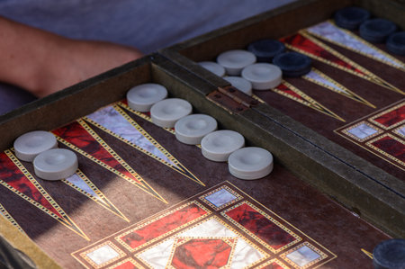 Detailed close-up of a traditional backgammon board with wooden checkers and dice during a game.