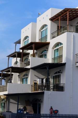 Contemporary white villas in a sunny Cyprus neighborhood. Clean lines, blue sky, and Mediterranean...
