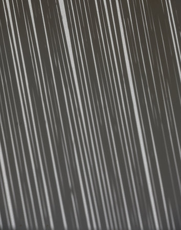 Soft shadow from a thatched reed roof falls on a white wall, creating a natural abstract pattern.