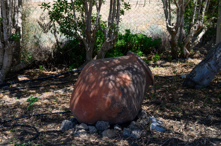 Vintage terracotta jug used as a rustic garden decoration under the Cyprus sun.の写真素材