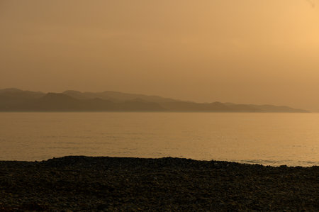 Golden sunset over the calm Mediterranean Sea on the coast of Cyprus.の写真素材