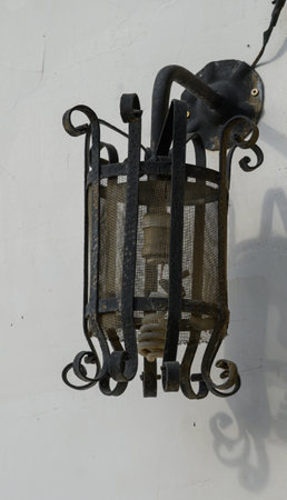Classic outdoor lantern fixed to a whitewashed wall of a traditional Cypriot house, casting a warm Mediterranean charm.の写真素材