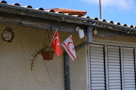 National flags of Turkey and Northern Cyprus displayed side by side on a house wall in a Cypriot village. Symbol of identity and regional pride.の写真素材