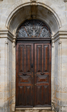 Authentic entrance of an old Cypriot house featuring a vintage wooden door with decorative elements and aged textures.の写真素材