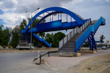 Modern pedestrian bridge crosses over a main road in Cyprus. Structure allows safe crossing for pedestrians above traffic flow.の写真素材