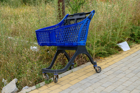 Shopping cart left near a roadside in Cyprus. Symbol of consumerism and neglect on a quiet local street.の写真素材