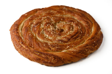 Freshly baked traditional Cypriot tahini roll (tahinopitta) with a rich sesame filling and golden crust.の写真素材