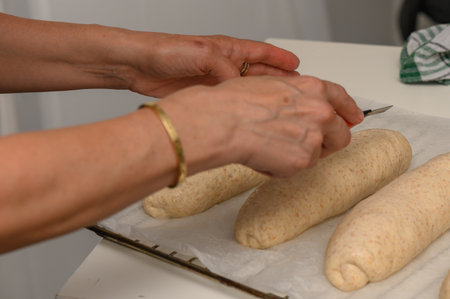 Applying Egg Wash to Homemade Graham Bread Before Bakingの写真素材