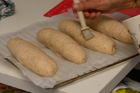 Woman Preparing Graham Bread with Egg Wash Before Baking