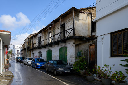 Narrow traditional street in Lefke, Cyprus with whitewashed houses, wooden doors and lush greenery.の写真素材