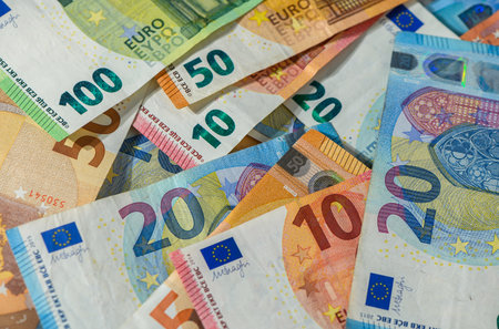 Many euro banknotes of different values 10, 20, 50, 100, 200 spread out, creating a money texture background for finance and economy conceptsの写真素材