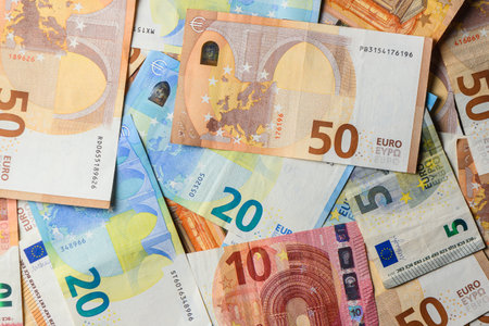 Euro banknotes of different denominations 5, 10, 20 and 50 on table in close-up, symbol of economy...