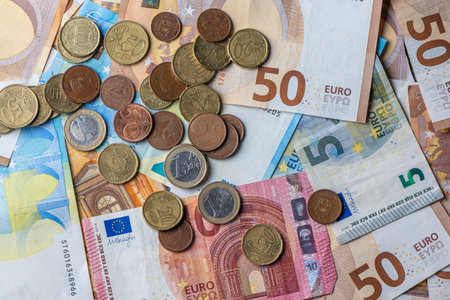 Close-up of mixed euro banknotes and coins used as texture background for finance and economy theme.