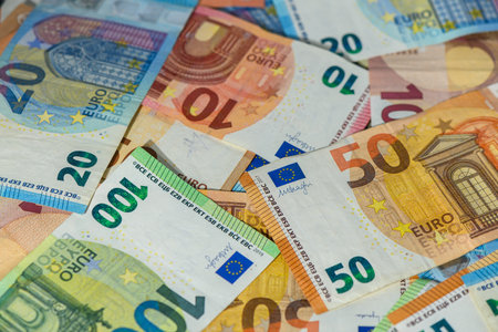 Colorful euro banknotes of 10, 20, 50, 100, and 200 denominations arranged as a background,...