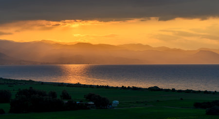 Scenic view of Morphou Bay in Cyprus at sunset, seen from a rooftop terrace. Beautiful sea, coastline, and warm evening sky perfect for travel and tourism concepts.の写真素材