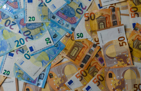 Closeup of Euro bills arranged on table, showing denominations and texture, representing banking,...