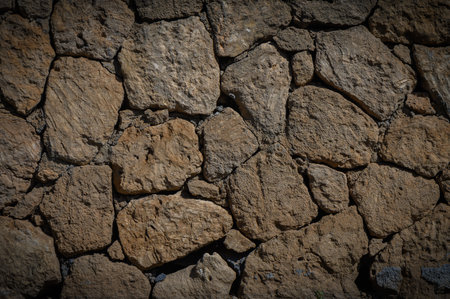 Rustic beige stone wall with warm tones, Mediterranean style, perfect as background for photography,...