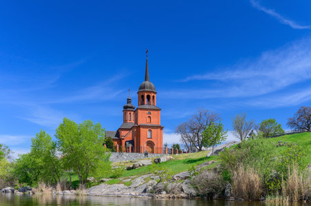 Spaso-Preobrazhenskaya Church reflected on calm reservoir water in Keleberda, Ukraine, creating a...