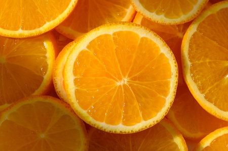 Oranges cut into slices and laid on surface. Bright citrus food background for cooking, design, and...