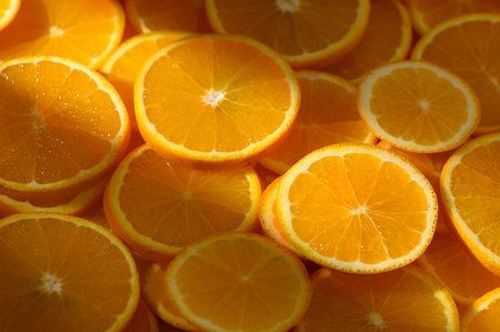 Orange rounds spread on surface creating a juicy citrus background.の写真素材