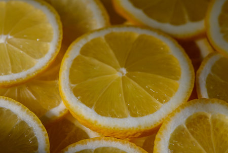 Lemons sliced into pieces and spread on surface making a bright citrus background.の写真素材