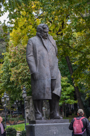 Bronze monument to poet Georgi Leonidze in a summer park in Tbilisi, green areas, walking paths, and urban landscape, popular spot for tourists.の写真素材