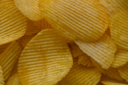 Close-up of appetizing potato chips spread in a plate. Perfect as a background for food photography, macro shots, and culinary projects.の写真素材