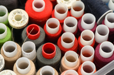 Close-up texture of colorful sewing thread spools forming a pattern perfect for craft, design, tailoring and textile backgrounds.の写真素材
