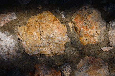 Rugged rustic stone wall illuminated by sunlight. Perfect background for travel photography,...