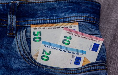 Euro notes of various denominations in denim pocket. Cash, money management, and finance concept for stock photography.の写真素材