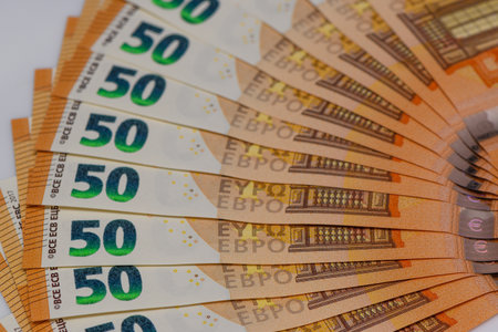 Fanned 50 euro notes spread on a wooden table. Cash, money, and personal finance concept for stock photography and financial illustrations.の写真素材