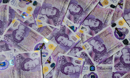 Many 20 GBP notes scattered across a table. Cash, money, and finance concept for stock and personal finance photography.の写真素材