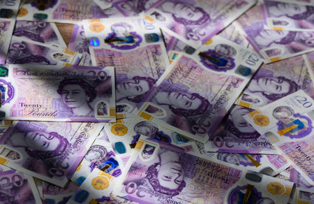 20 GBP currency notes randomly scattered on a table. Concept of cash, money, and finance for stock photography and financial illustrations.の写真素材