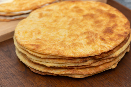 Close-up of a woman carefully assembling layers of homemade puff pastry cake.
