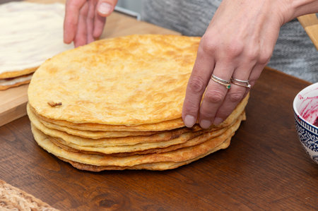 Close-up of assembling a cake with jam between layers, homemade pastry process in the kitchen.