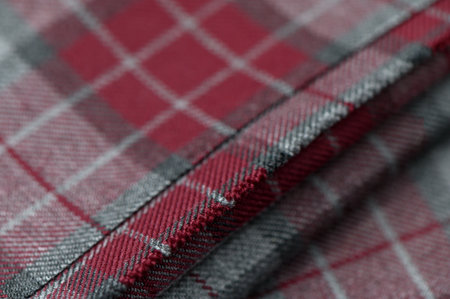 Close-up of bright red fabric with contrasting tartan pattern, clear texture and details.の写真素材