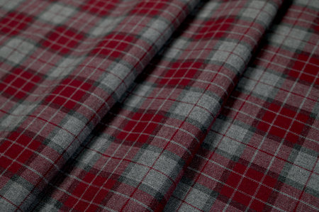 Close-up of soft red wool fabric in Scottish tartan pattern, texture and pattern clearly visible.の写真素材
