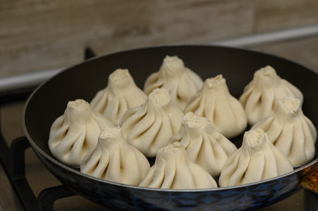 Delicious khinkali cooking on a skillet. Close-up, traditional Georgian dish, homemade kitchen, tasty food.の写真素材