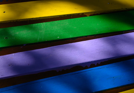 Close-up of colorful wooden bench planks. Painted wood surface with aged texture, ideal as a natural...