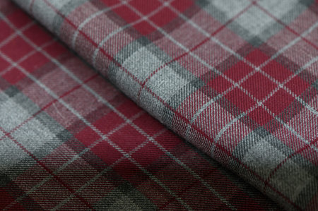 Classic Scottish tartan check in red, green, and blue tones. Wool fabric texture with intersecting stripes creates an authentic background for design and photos.の写真素材