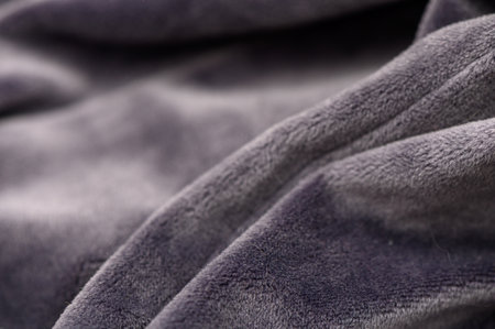 Macro of gray fabric with soft pile and dense thread weave. Muted gray shade and velvety texture create an elegant background for minimalist and interior compositionsの写真素材