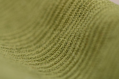 Macro of dense green fabric with clear thread weave and light pile. Deep olive shade and relieved texture create a natural background for clothing, bags, and interior decor.の写真素材