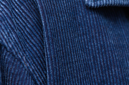 Corduroy with rich blue shade and relieved ridges in close view. Velvety surface and light play form an elegant background for clothing design and decor.の写真素材