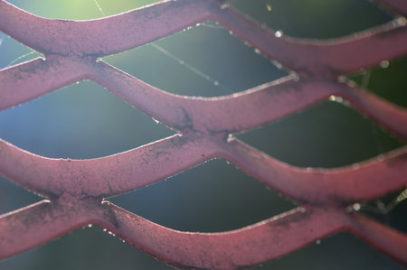 Close-up of corrugated sheet with pronounced ribs, matte and glossy metal areas. Cool gray shade and wavy relief form a strict background for graphic works and industrial aesthetics.の写真素材