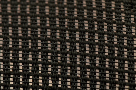 Macro shot of woven chair back made of natural vine with thread weave and warm brown tones. Relieved...