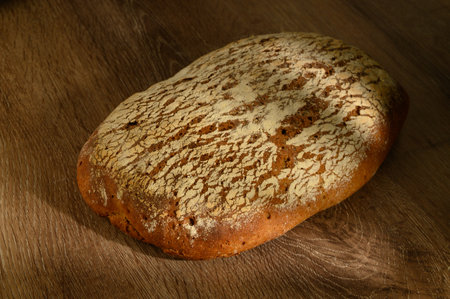 Freshly baked rustic rye bread resting on a traditional wooden table, showcasing natural ingredients...