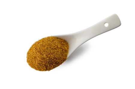 Top-down view of traditional Svaneti salt in a white ceramic spoon on white background. This perspective perfectly showcases the salt's texture and spice blend composition.の写真素材