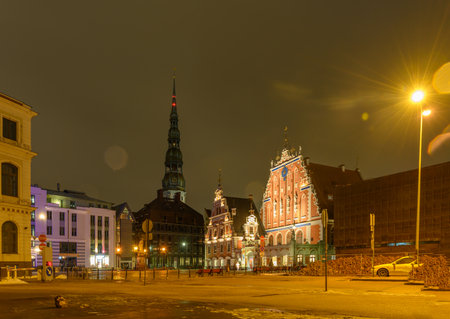 A breathtaking night view of Town Hall Square in Old Riga, Latvia. Historic buildings illuminated against the dark sky, creating a magical atmosphere in this UNESCO World Heritage site.の写真素材