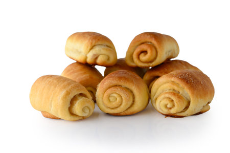 Studio photograph of freshly baked buns with cinnamon and sugar isolated on a clean white...
