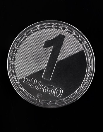High resolution studio photograph of a Georgian 1 lari coin in close up, isolated on a black...